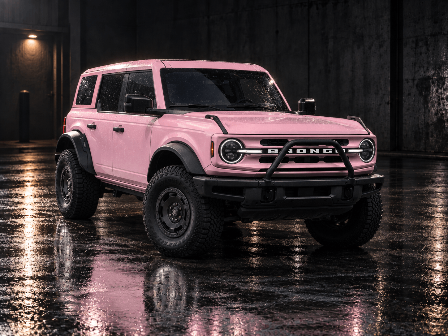 Ford Bronco wrapped in gloss pink vinyl with black fender flares and off-road wheels